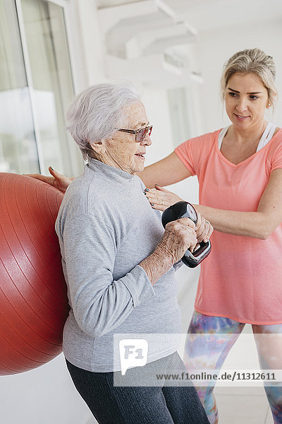 Senior woman exercising with fitness instructor