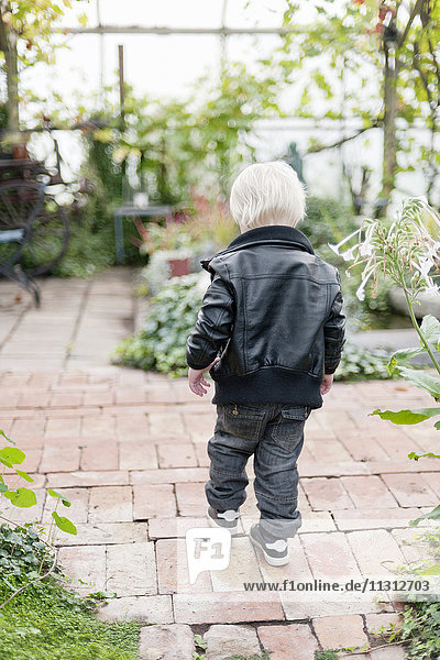 Kleiner Junge läuft im Hinterhof