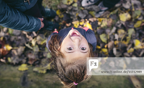 Portrait of laughing little girl standing in the woods  top view