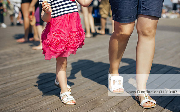 USA  New York  Coney Island  Mutter und kleine Tochter auf Holzsteg  Teilansicht