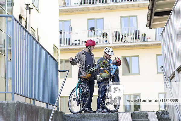 Eltern mit Sohn und Fahrrädern beim Bauen