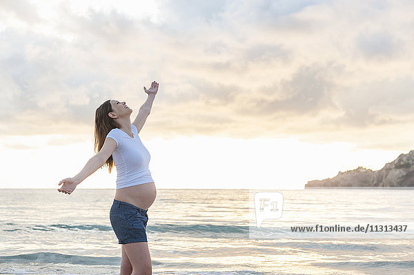 Glückliche schwangere Frau am Strand