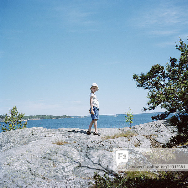 Portrait of girl standing on rock by lake