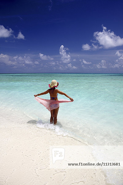 Malediven  Frau im flachen Wasser stehend