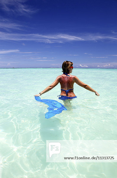 Malediven  Frau im flachen Wasser stehend