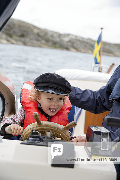 Lächelndes Mädchen am Steuer eines Bootes