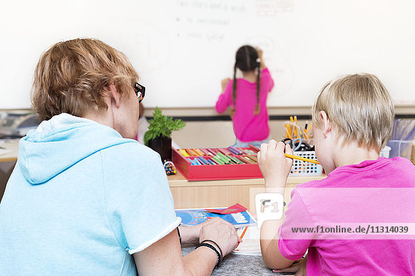 Teacher assisting students in classroom