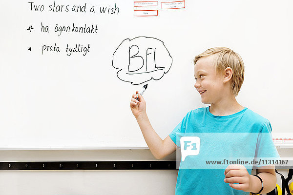 Boy standing in front of whiteboard