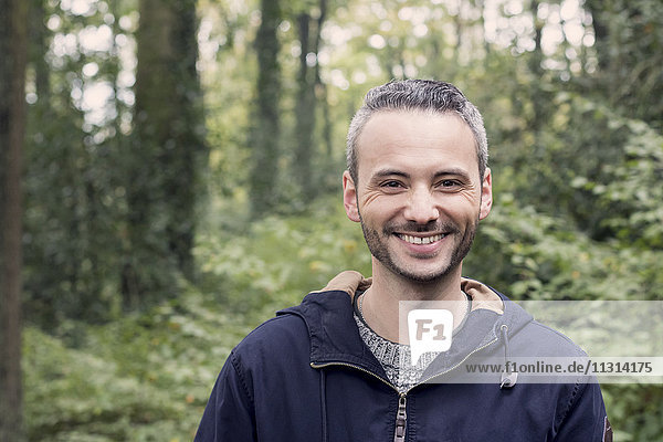 Porträt eines lächelnden Mannes im Wald