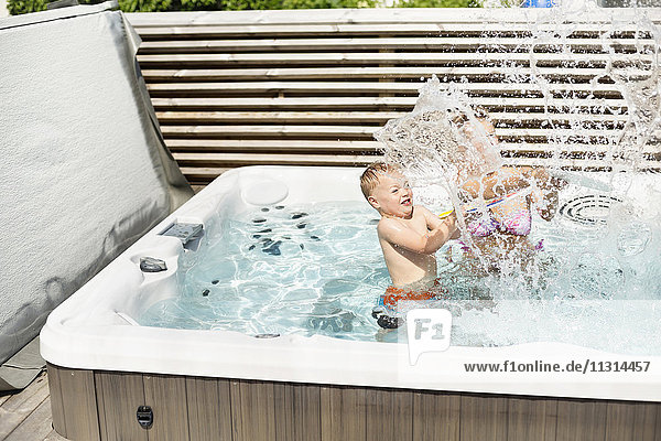 Mother with son splashing in swimming-pool