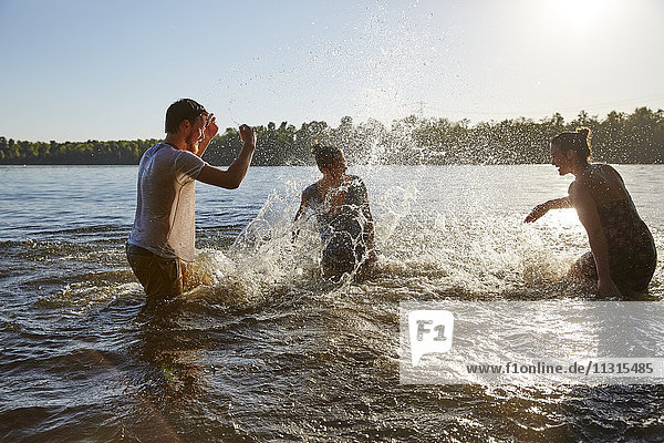 Playful friends splashing in a lake