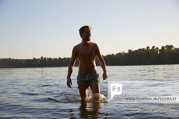 Glücklicher junger Mann in einem See