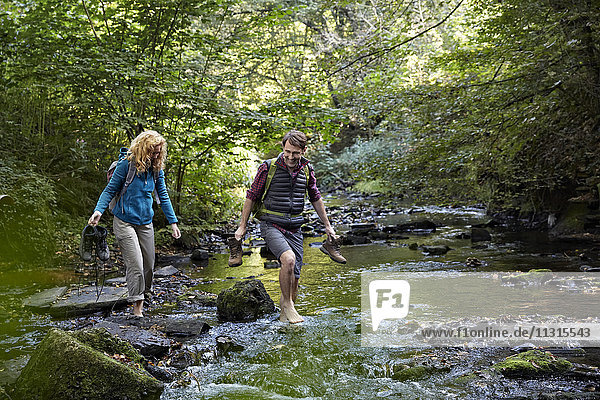 Couple hiking crossing a river