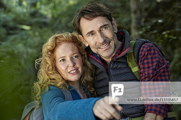 Couple hiking in forest  pointing at something