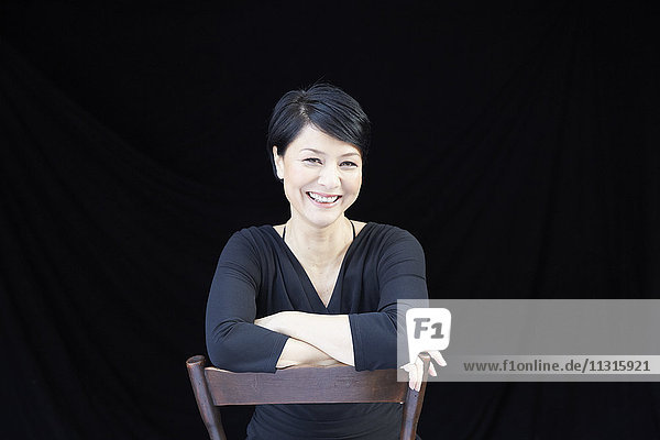Porträt der lächelnden Frau auf dem Stuhl