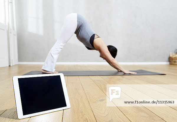 Frau praktiziert Yoga hinter der Tafel