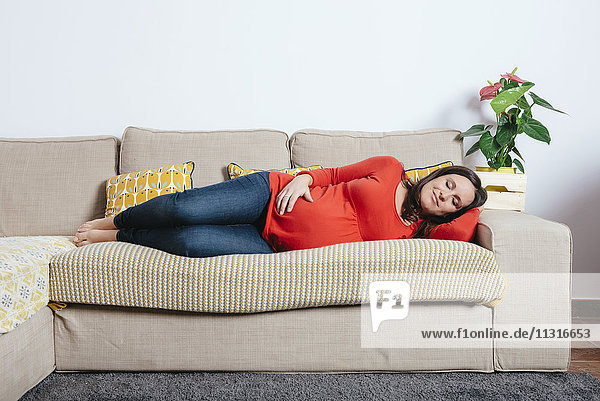 Schwangere Frau schläft auf der Couch