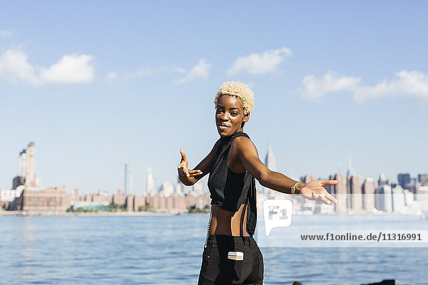 USA  New York City  Brooklyn  lächelnde junge Frau am East River