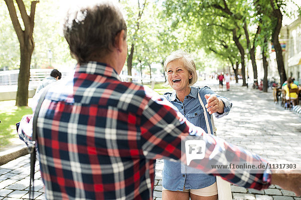 Porträt einer glücklichen älteren Frau,  die den älteren Mann begrüßt.