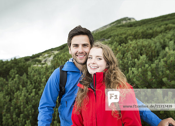 Porträt eines lächelnden jungen Paares auf einer Wanderung