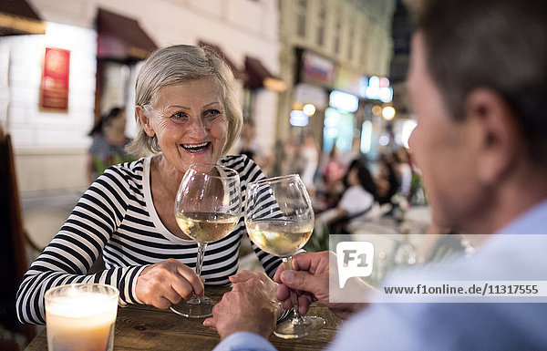 Senior couple drinking wine at an outdoor bar