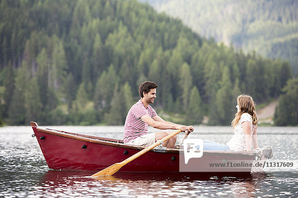 Young couple in rowing boat on the lake