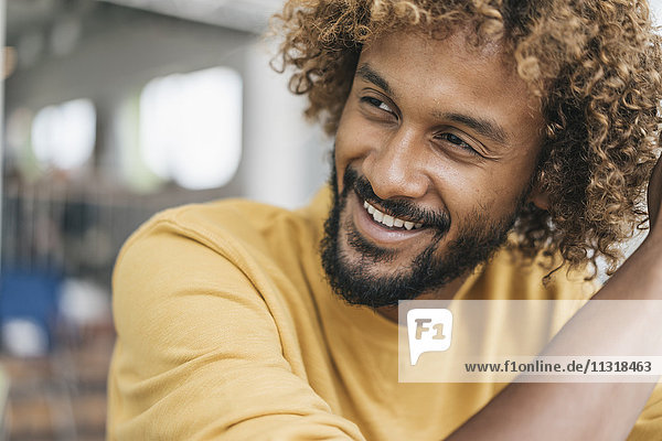 Lächelnder junger Mann mit Afro-Locken  Portrait
