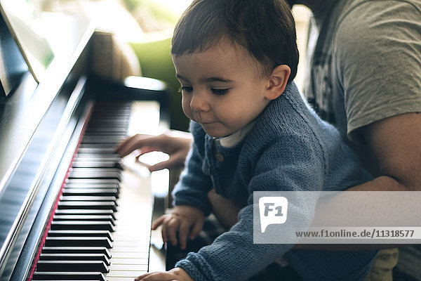 Kind und Vater beim Klavierspielen