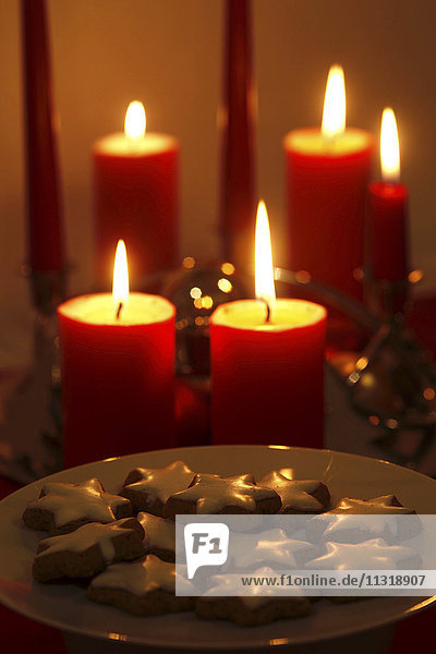 Lighted candles and plate of cinnamon stars