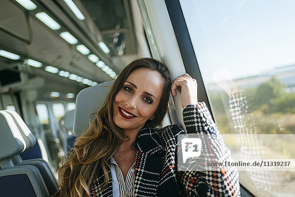 Porträt einer lächelnden Frau im Zug