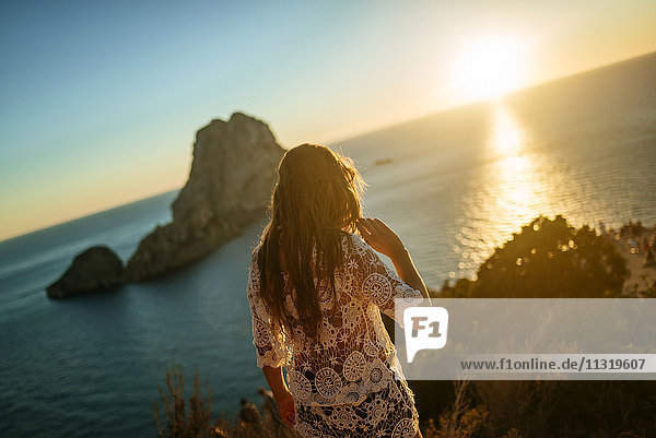 Spain  Ibiza  Woman looking at the sea and Es Vedra island at sunset
