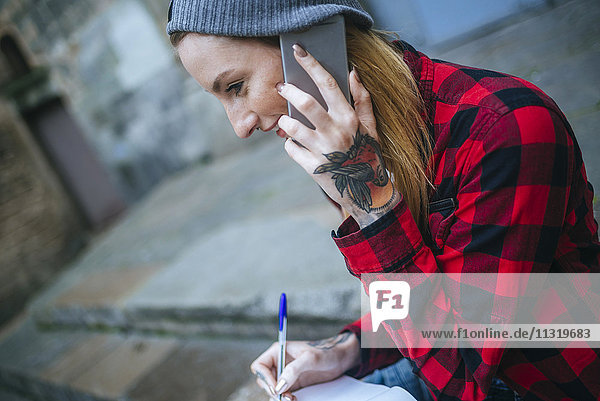 Tattooed young woman talking on mobile phone