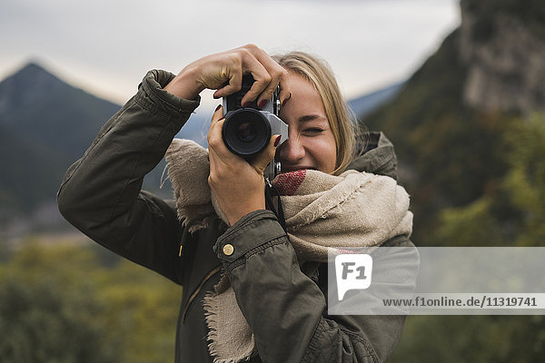 Junge Frau beim Fotografieren im Freien