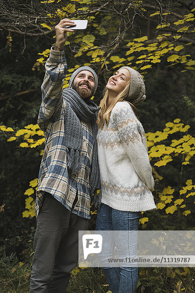 Junges Paar im Herbst im Freien mit einem Selfie