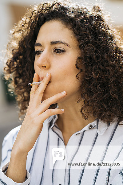 Porträt der rauchenden jungen Frau