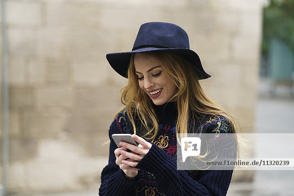 Smiling young woman looking at cell phone