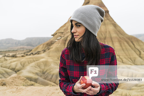 Spain  Navarra  Bardenas Reales  young woman with apple in nature park