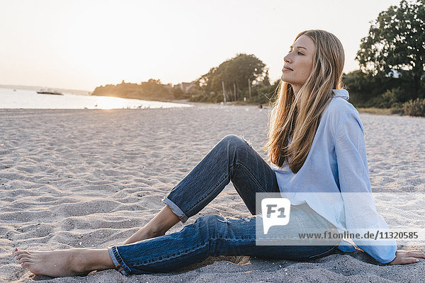 Young woman relaxing on the beach in the evening