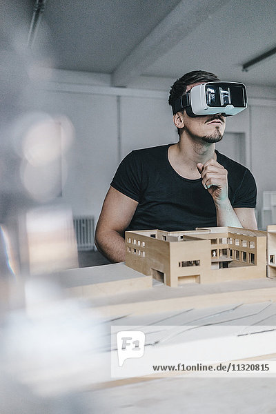 Man with architectural model and VR glasses