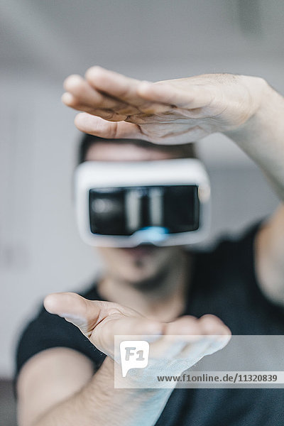 Man with raised hands wearing VR glasses