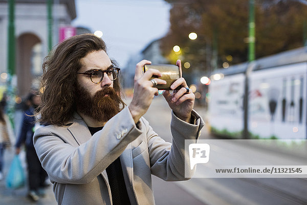 Stylish young man in the city taking a selfie
