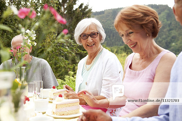 Senior ladies eating cake in garden