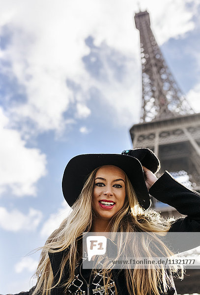 Frankreich  Paris  Porträt einer lächelnden Frau vor dem Eiffelturm