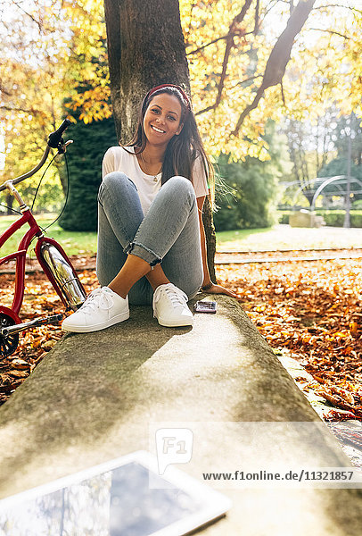 Porträt einer lächelnden jungen Frau in einem Park im Herbst