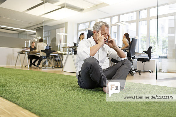 Businessman meditating in office