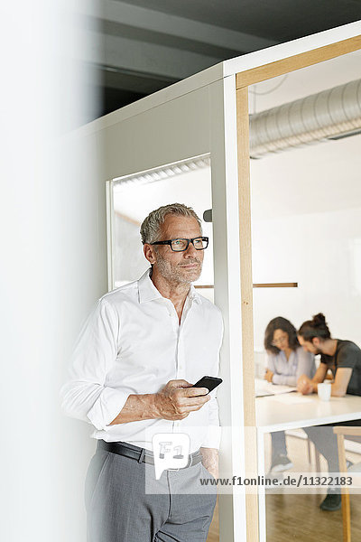 Businessman with cell phone in office