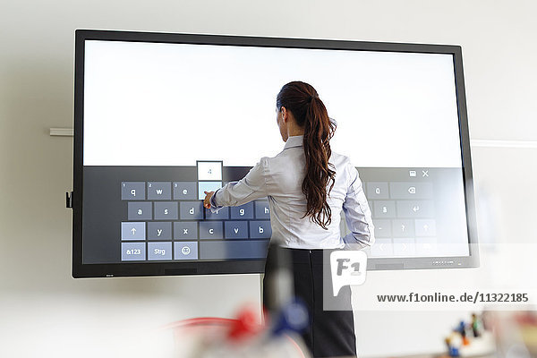 Businesswoman using projection of a keyboard in conferene room