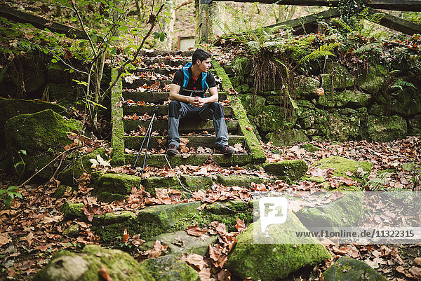 Hiker sitting on stairs having a break