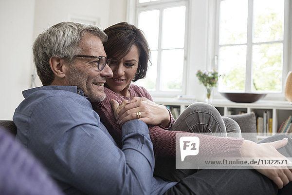 Smiling mature couple at home on the sofa