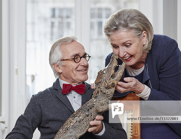 Playful senior couple with taxidermised crocodile
